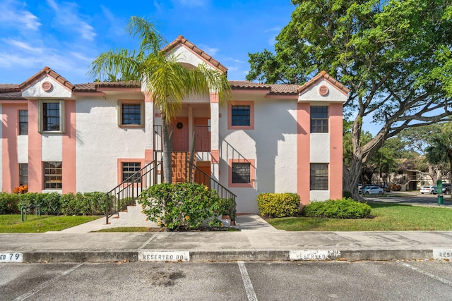301 Norwood Ter Unit N230, Boca Raton, FL 33431 - view of front facade with stucco siding, a tile roof, and uncovered parking