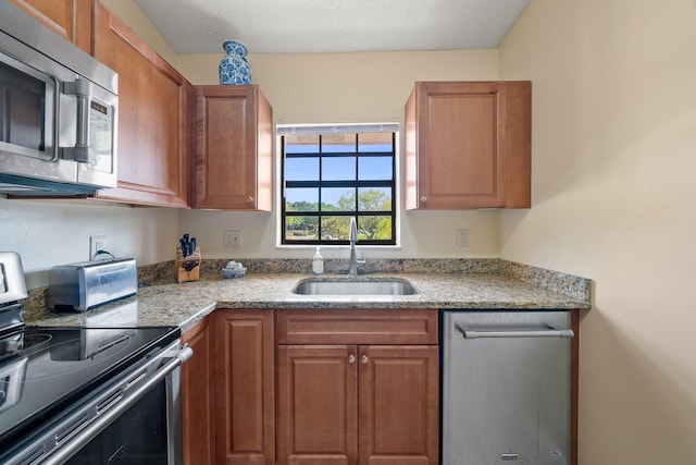 301 Norwood Ter Unit N230, Boca Raton, FL 33431 - kitchen with a sink, brown cabinets, appliances with stainless steel finishes, and a textured ceiling