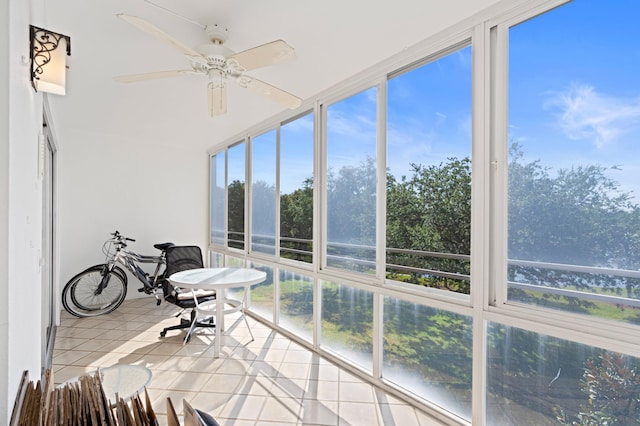 sunroom featuring tile patterned floors and ceiling fan