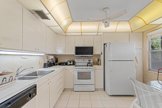 kitchen featuring light countertops, a sink, light tile patterned floors, white appliances, and visible vents