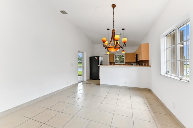 9827 Galleon Dr, West Palm Beach, FL 33411 - unfurnished dining area with lofted ceiling, light tile patterned flooring, a notable chandelier, and visible vents