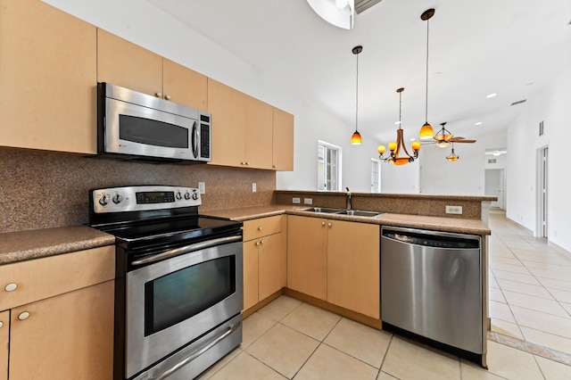 9827 Galleon Dr, West Palm Beach, FL 33411 - kitchen with a sink, a peninsula, stainless steel appliances, decorative backsplash, and light tile patterned floors