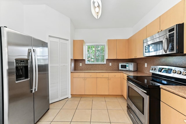9827 Galleon Dr, West Palm Beach, FL 33411 - kitchen with light tile patterned floors, appliances with stainless steel finishes, decorative backsplash, and light brown cabinets