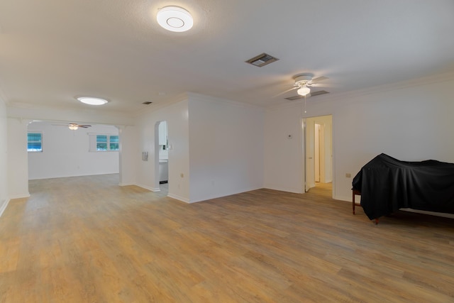 4375 Forest Ln, Palm Springs, FL 33406 - unfurnished room with a ceiling fan, arched walkways, ornamental molding, light wood-style floors, and baseboards