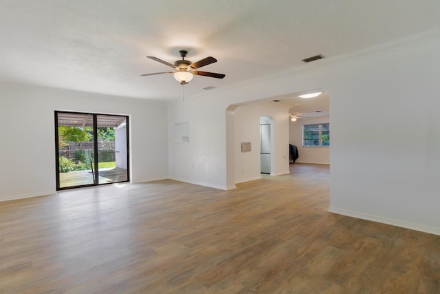 4375 Forest Ln, Palm Springs, FL 33406 - empty room featuring ceiling fan, arched walkways, healthy amount of natural light, crown molding, and light wood finished floors