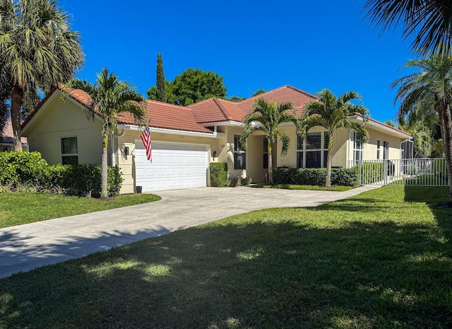 mediterranean / spanish-style house featuring stucco siding, fence, an attached garage, a tiled roof, and a front lawn