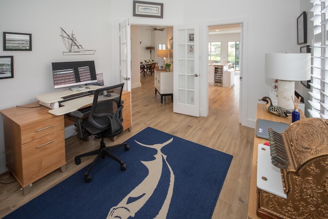 office space with baseboards, wood finished floors, french doors, and a ceiling fan