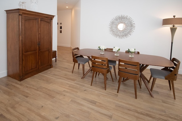 dining area with baseboards and light wood finished floors
