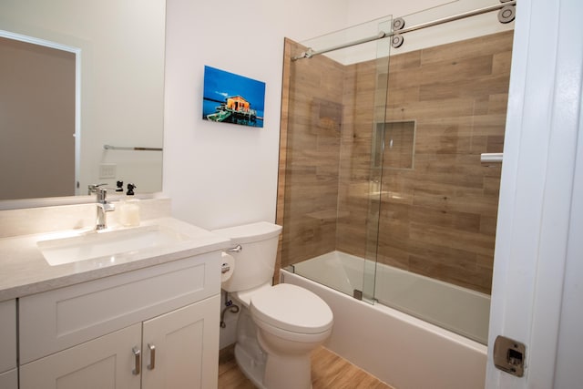 bathroom with toilet, vanity, enclosed tub / shower combo, and wood finished floors