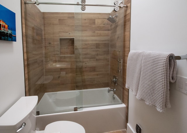 bathroom featuring combined bath / shower with glass door and toilet