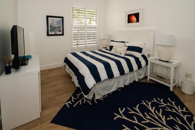 bedroom featuring baseboards and wood finished floors