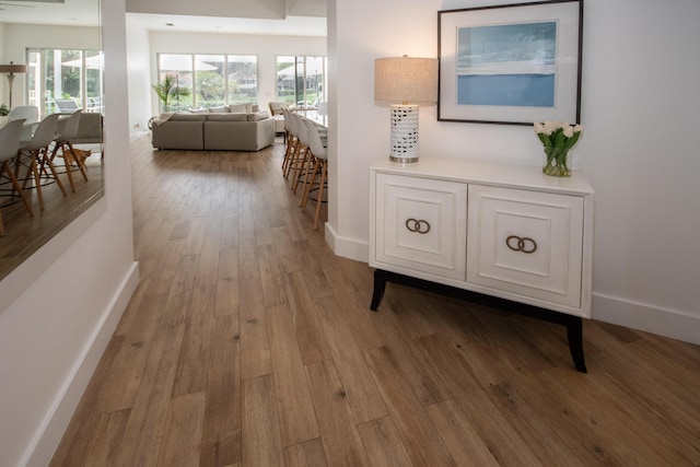hallway featuring baseboards and wood finished floors