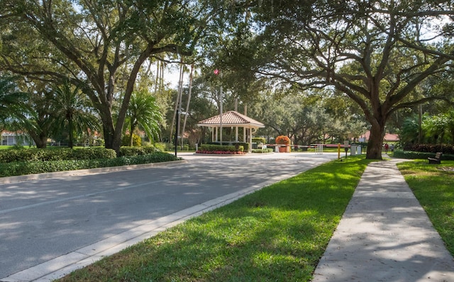 view of street featuring sidewalks, a gated entry, and curbs
