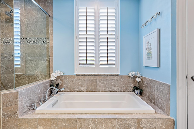 bathroom with a tile shower and a bath
