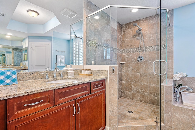 full bathroom with vanity, visible vents, a raised ceiling, and a stall shower