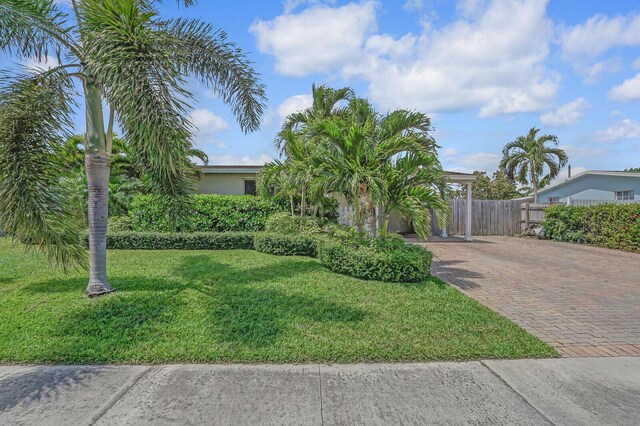 property entrance featuring visible vents, a carport, stucco siding, and fence