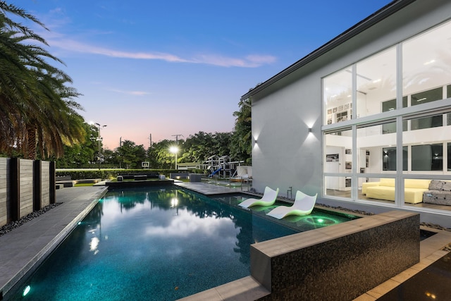 7047 San Sebastian Cir, Boca Raton, FL 33433 - pool at dusk featuring a pool with connected hot tub