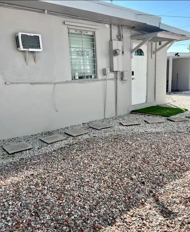 view of home's exterior with a wall unit AC