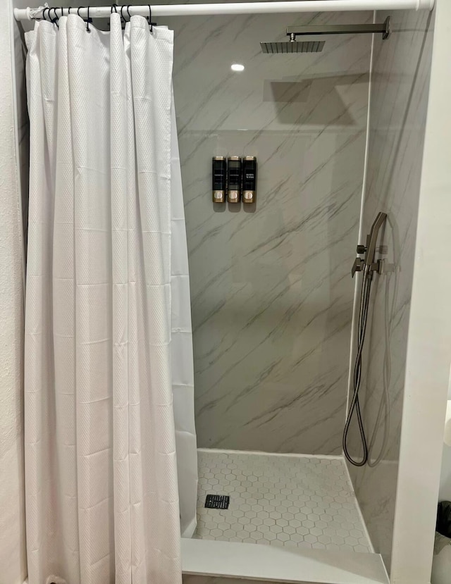 bathroom featuring a marble finish shower