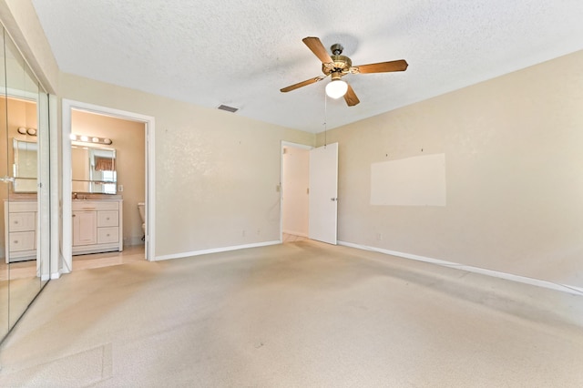 6472 Overland Dr, Delray Beach, FL 33484 - unfurnished bedroom with light carpet, ensuite bathroom, visible vents, and a textured ceiling