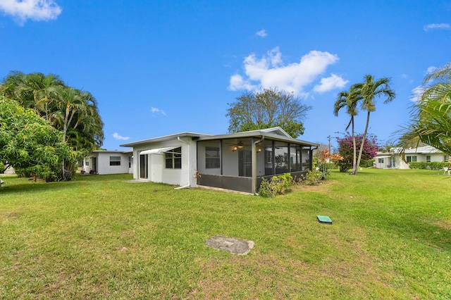 6472 Overland Dr, Delray Beach, FL 33484 - rear view of house featuring a sunroom, stucco siding, and a lawn