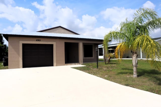 6763 Mar Pacifico, Fort Pierce, FL 34950 - view of front of house featuring stucco siding, a garage, concrete driveway, and a front yard