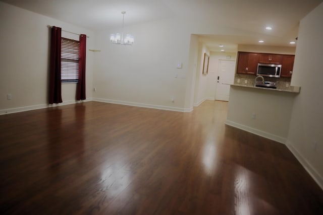 6763 Mar Pacifico, Fort Pierce, FL 34950 - unfurnished living room featuring dark wood-type flooring, baseboards, a chandelier, and recessed lighting