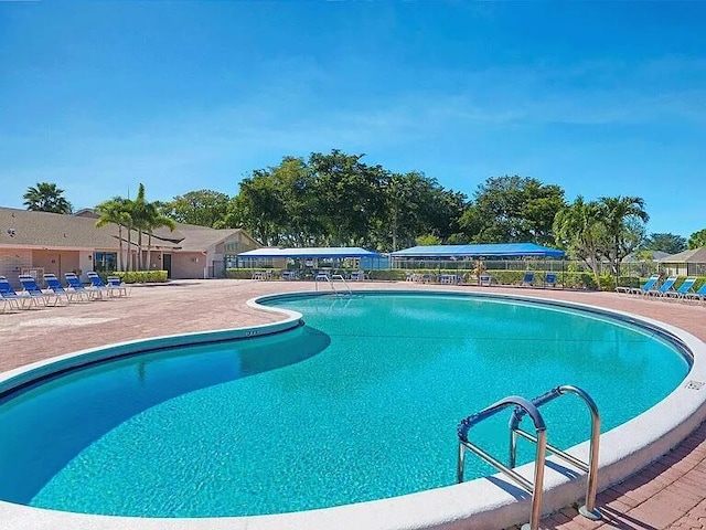 pool with a patio area and fence