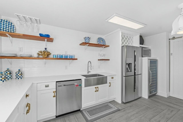 kitchen featuring open shelves, a sink, beverage cooler, stainless steel appliances, and decorative backsplash