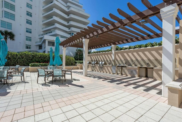 view of patio featuring an outdoor kitchen, a pergola, and outdoor dining area