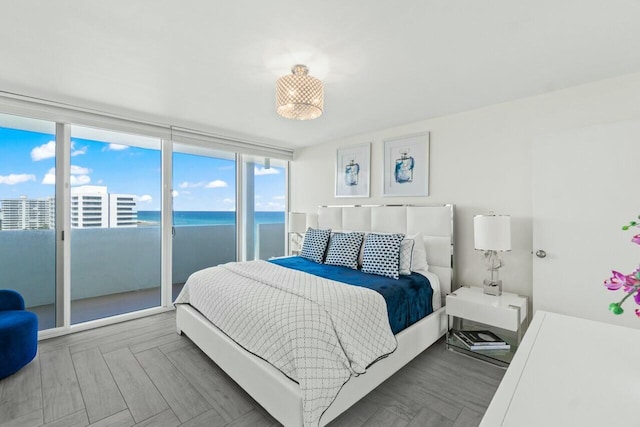 bedroom featuring a water view and access to exterior