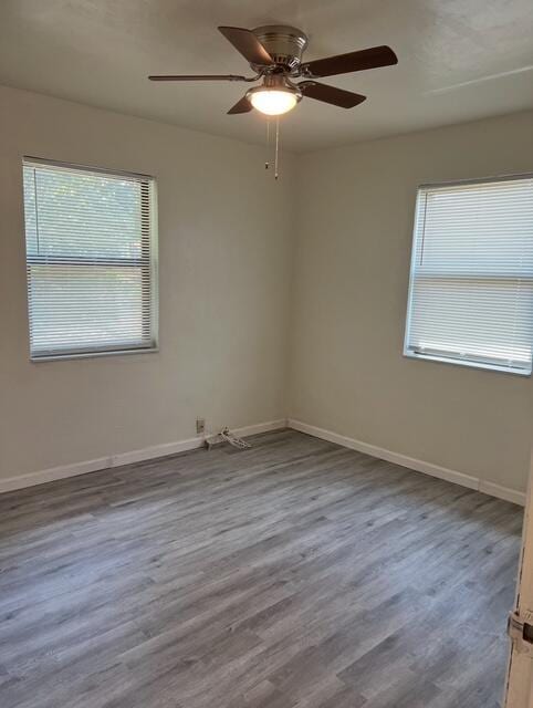 unfurnished room with baseboards, ceiling fan, and wood finished floors