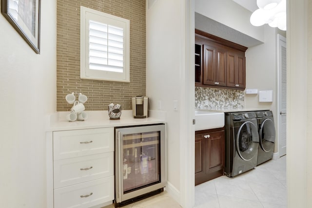 12479 Aviles Cir, Palm Beach Gardens, FL 33418 - laundry room featuring beverage cooler, cabinet space, washing machine and clothes dryer, and light tile patterned floors