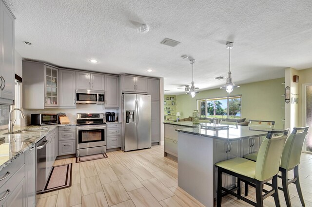 3412 Lake Osborne Dr, Lake Worth Beach, FL 33461 - kitchen featuring dishwasher, a textured ceiling, dark stone countertops, recessed lighting, and gray cabinets