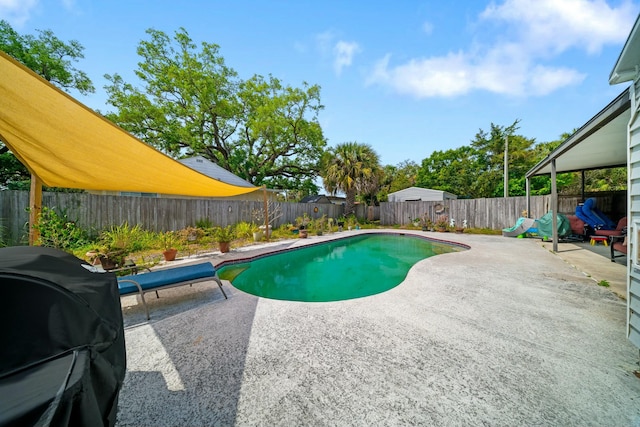 view of pool with a fenced backyard, a fenced in pool, area for grilling, and a patio area
