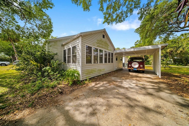 view of property exterior featuring an attached carport and concrete driveway