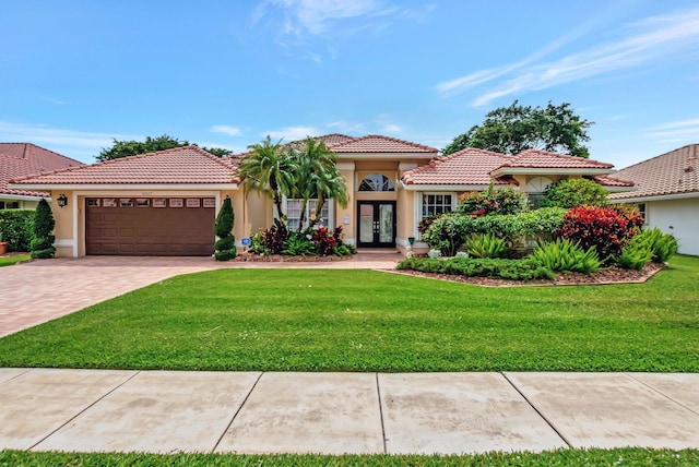 10423 Canoe Brook Cir, Boca Raton, FL 33498 - mediterranean / spanish-style house with driveway, a tiled roof, french doors, and a front yard