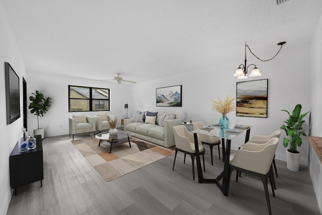 132 Manchineel Ct, Royal Palm Beach, FL 33411 - living area featuring light wood finished floors, baseboards, and ceiling fan with notable chandelier