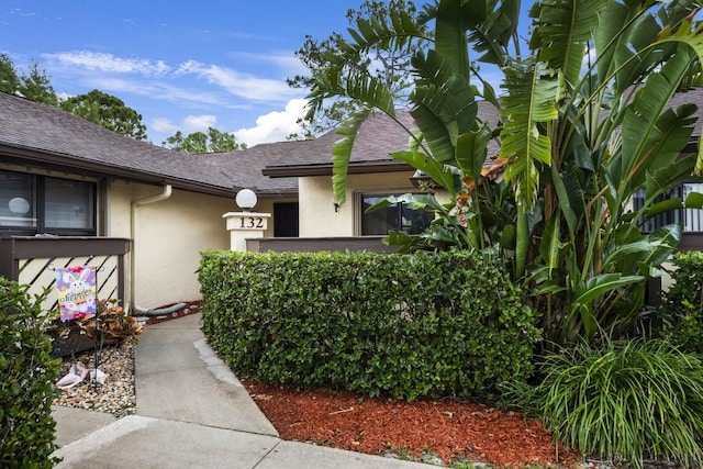 132 Manchineel Ct, Royal Palm Beach, FL 33411 - view of exterior entry with a shingled roof and stucco siding