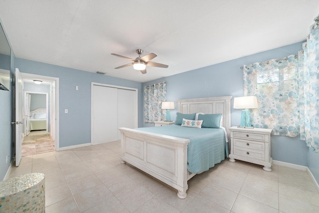 bedroom featuring light tile patterned flooring, a closet, a ceiling fan, baseboards, and visible vents