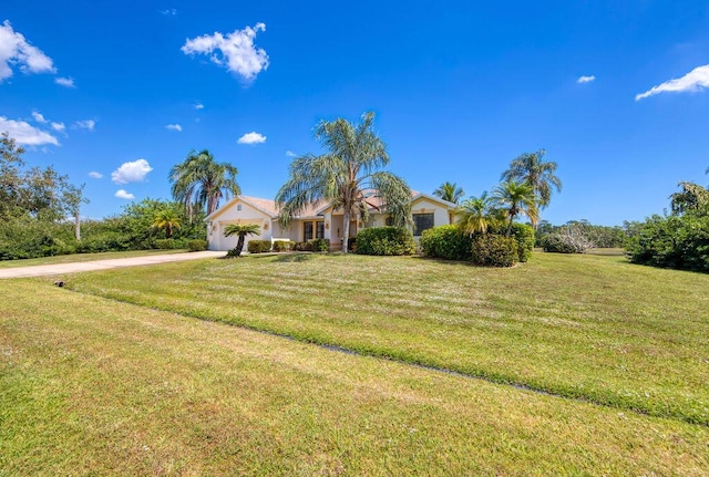 3381 SE E Snow Rd, Port Saint Lucie, FL 34984 - view of front facade with stucco siding, an attached garage, a front lawn, and concrete driveway