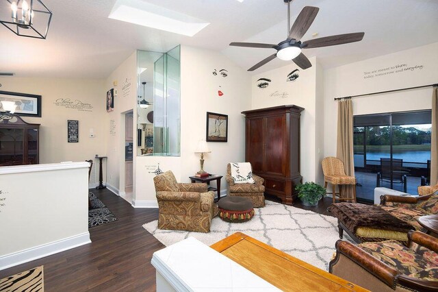 3381 SE E Snow Rd, Port Saint Lucie, FL 34984 - living area with baseboards, dark wood-style floors, vaulted ceiling with skylight, and ceiling fan