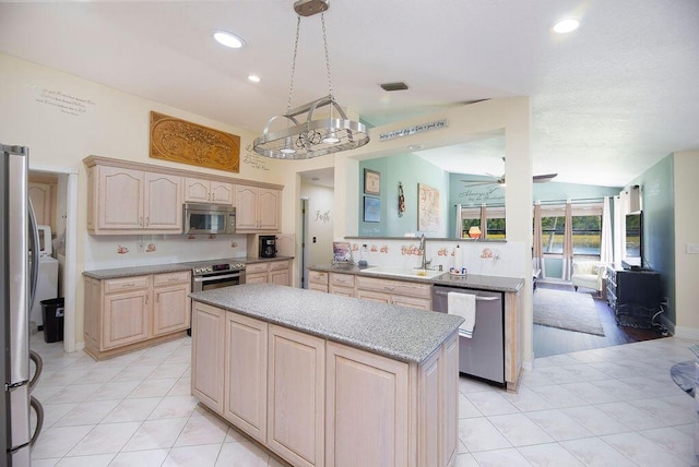 3381 SE E Snow Rd, Port Saint Lucie, FL 34984 - kitchen with a sink, light brown cabinetry, a center island, stainless steel appliances, and ceiling fan