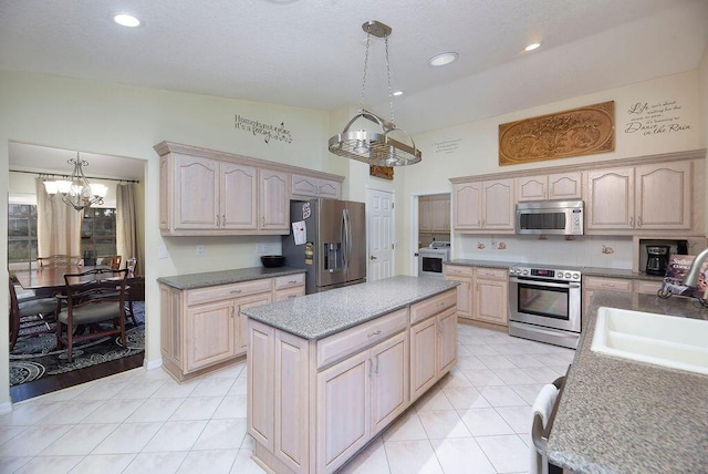 3381 SE E Snow Rd, Port Saint Lucie, FL 34984 - kitchen with a chandelier, stainless steel appliances, a kitchen island, a sink, and light brown cabinetry