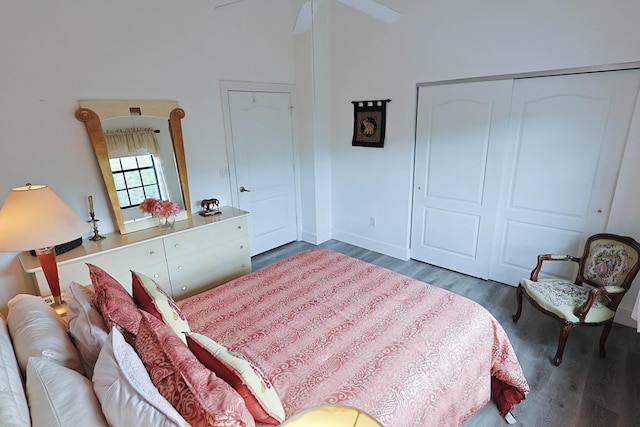 bedroom featuring baseboards, wood finished floors, and a closet