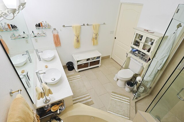 bathroom featuring double vanity, a shower stall, and a sink