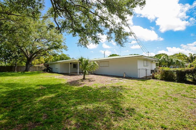 1034 Grandview Blvd, Fort Pierce, FL 34982 - back of house with fence and a lawn