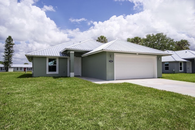 view of front facade featuring a front lawn, metal roof, concrete driveway, an attached garage, and stucco siding