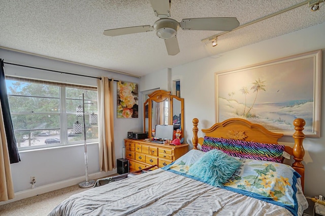 carpeted bedroom with a textured ceiling and a ceiling fan