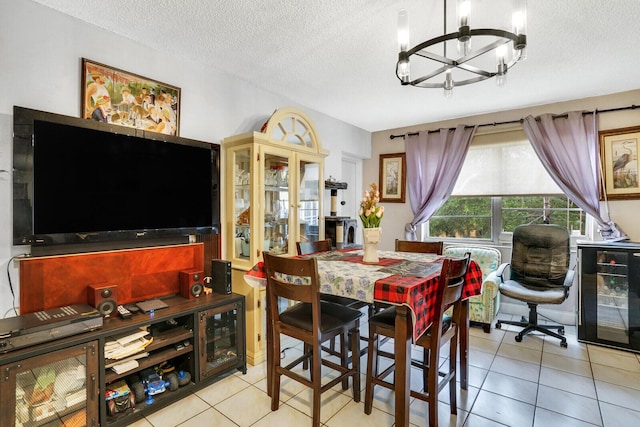 dining room featuring a chandelier, a textured ceiling, tile patterned flooring, and beverage cooler